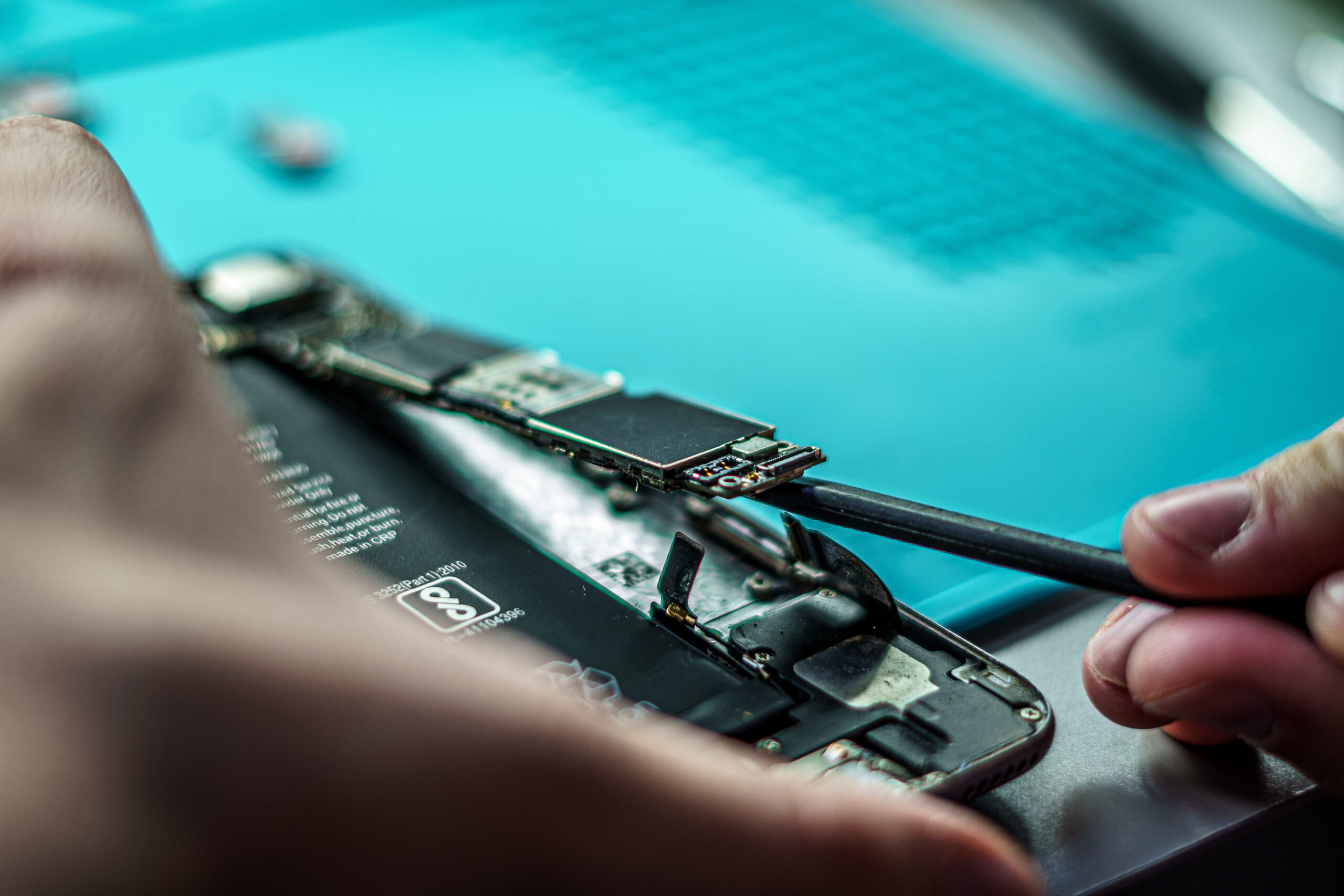 Closeup shot of a person repair a mobile in mobile repair smartphone workshop